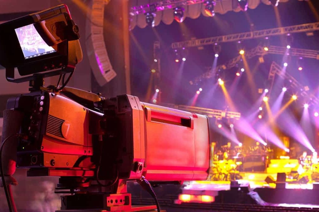Broadcast-Kamera vor einer beleuchteten Live-Bühne