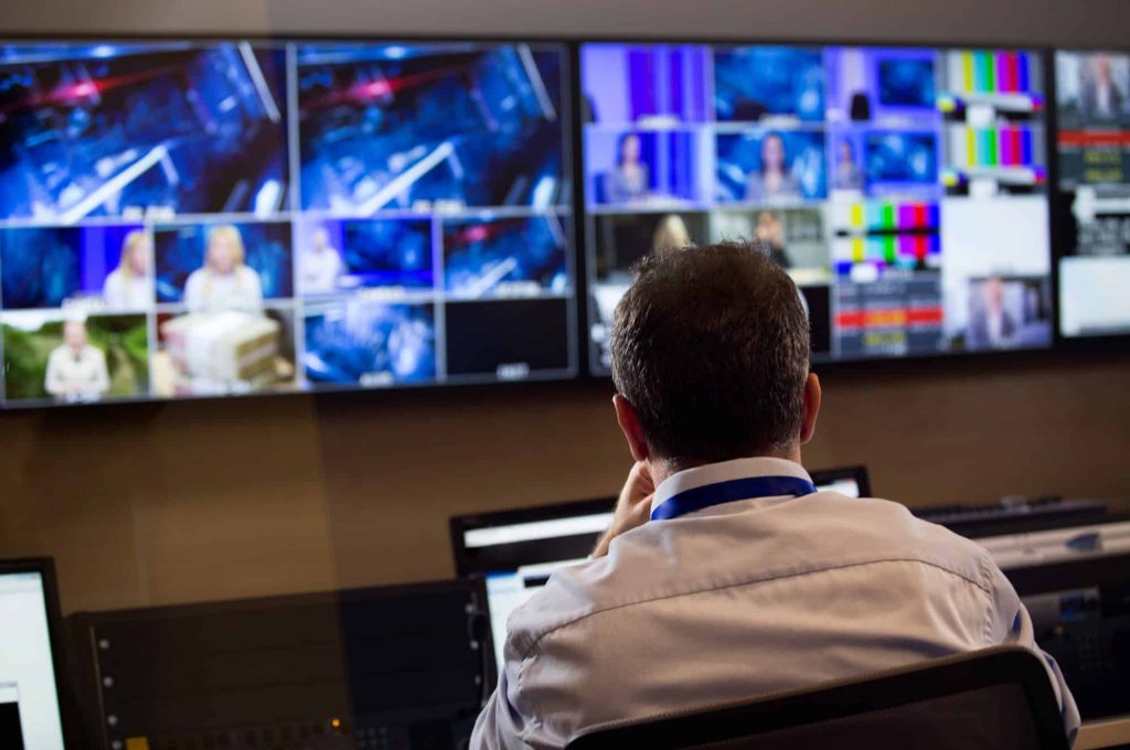 Mitarbeiter vor Kontrollmonitoren in der Postproduktion